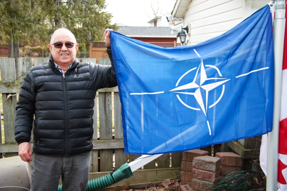 Peter Pozzo with a NATO flag gifted to him by neighbour Stephen Givens, March 12, 2024.