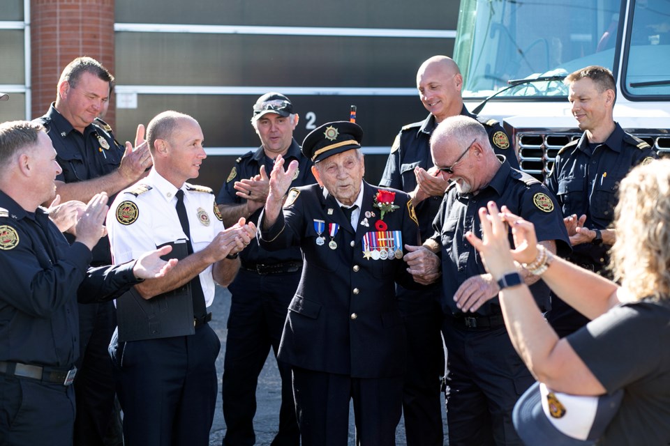 Jens 'Jake' Lamour waves a thanks after the firefighters at No. 1 Hall sing him happy birthday for his 100th on Wednesday.