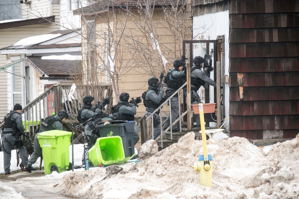 Sault Police officers with the Emergency Services Unit prepare to raid a home in the 200-block of Cathcart Street during an investigation in the area of Cathcart Street and John Street on Dec. 30, 2024.