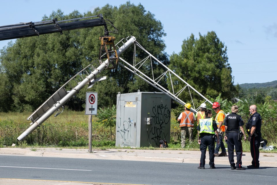 A damaged railway signal is lifted by crane at the scene of a collision near Carmen’s Way and Second Line East on Tuesday afternoon. Kenneth Armstrong/SooToday