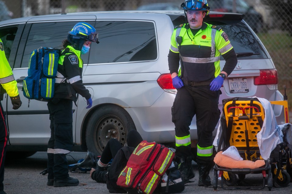 Paramedics assisting female victim, who was taken to hospital as a result of the collision.