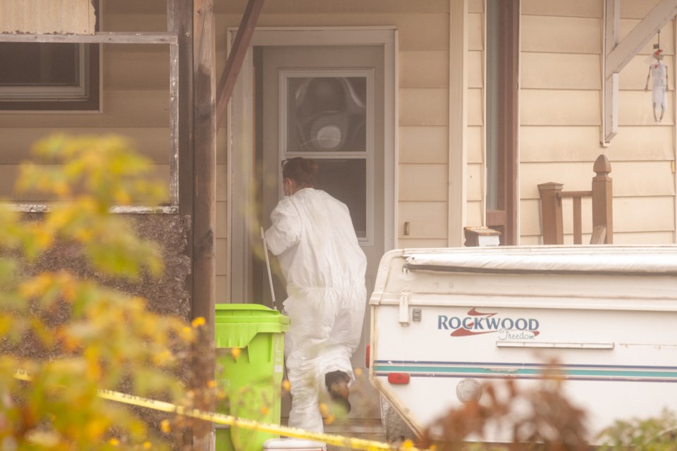 A person in a protective suit enters a Second Line East home, one of two Sault Ste. Marie addresses involved in a mass murder-suicide investigation.