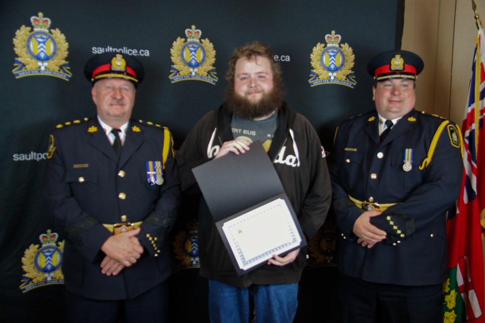 Liam Frenette receives a commendation letter from Sault Police Chief Hugh Stevenson and Deputy Chief Brent Duguay at the 36th annual Sault Police Community Awards at the Delta Hotel, May 16, 2024.