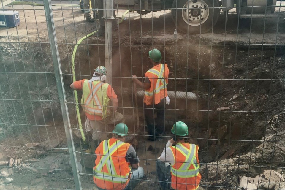 Work crews are shown on Wednesday night after a watermain  break poured into the basement at the Downtown Association, forcing cancellation of a board meeting