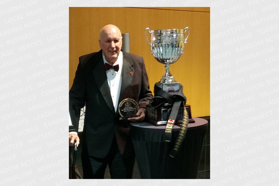 Rudy Timmerman stands beside the Masami Tsuruoka Lifetime Achievement Cup. He is the tenth person to receive the award since the Canadian Black Belt Hall Of Fame was established in 2006, and his name will be engraved on the most prestigious award in Canadian Martial Arts.