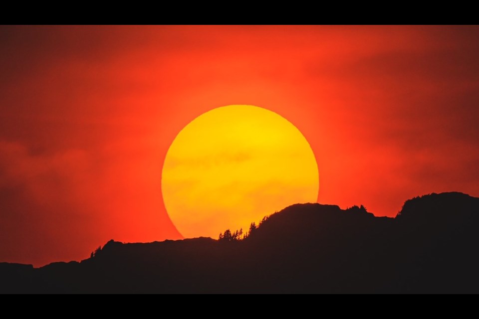 Photographer Robert Davidson Keir says that with atmospheric dispersion of the smoke and the resulting refraction, we get lots of reds, oranges and yellows as the sun sets — a long lens and smaller aperture also help.
This shot is the sunset over The Castle (510m) just west of Squamish.