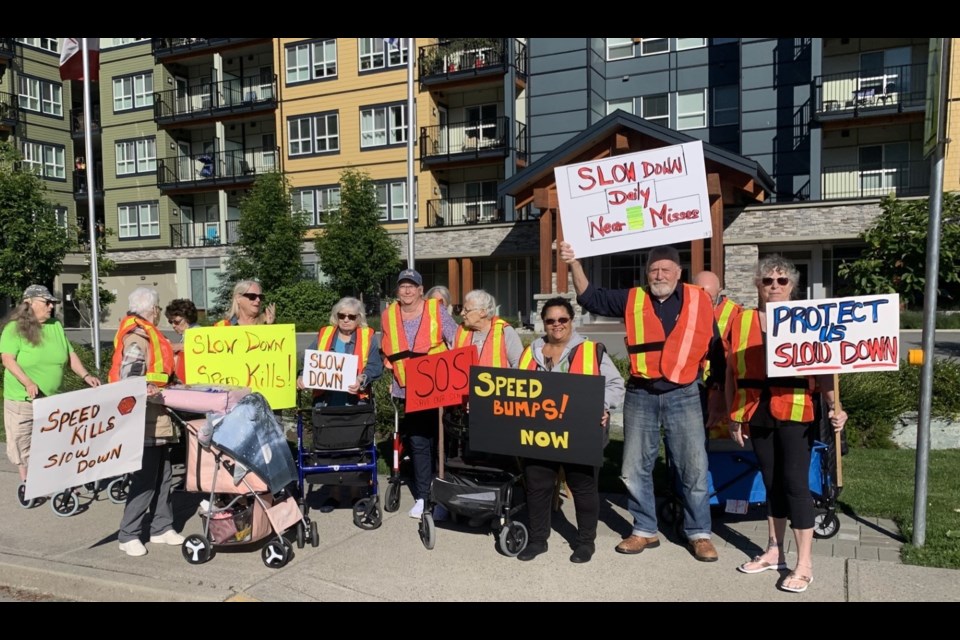 More than one dozen Squamish seniors are waving placards and chanting this hour at the crosswalk on Third Avenue, in front of the Westwinds Senior Living residence. 