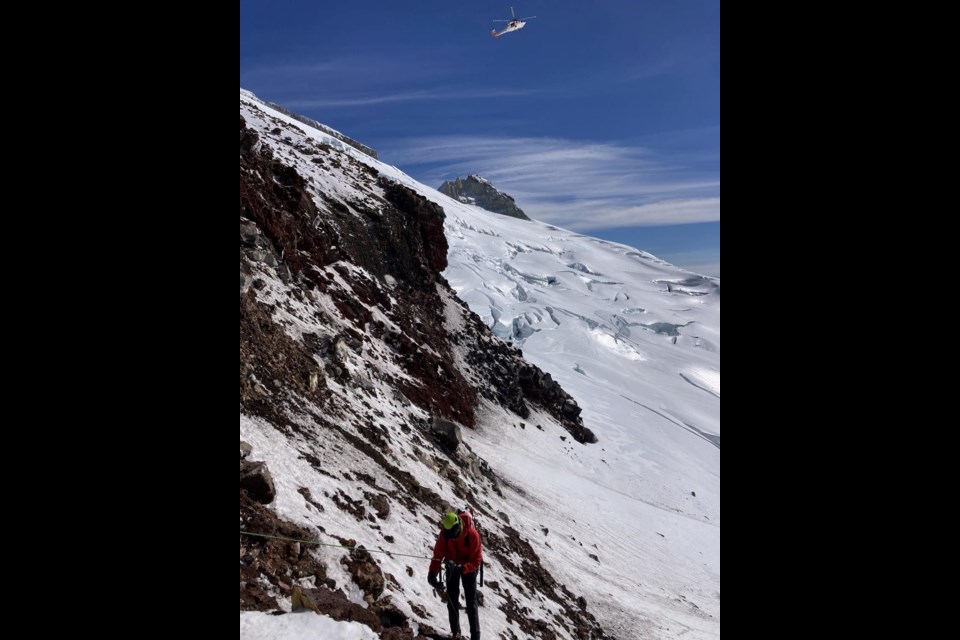 A Mountain Rescue volunteer rappels onto Mount Baker's Easton Glacier while searching for the overdue climber.