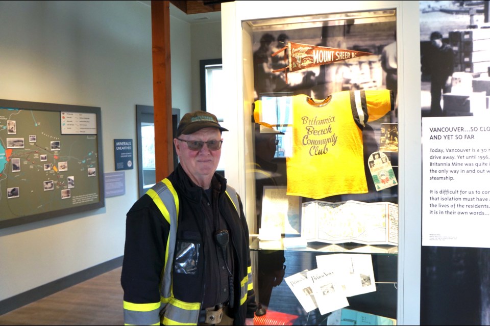 Marshall Tichauer beside the baseball jersey he wore back when he worked at the mine. It is now on display at the museum.                              