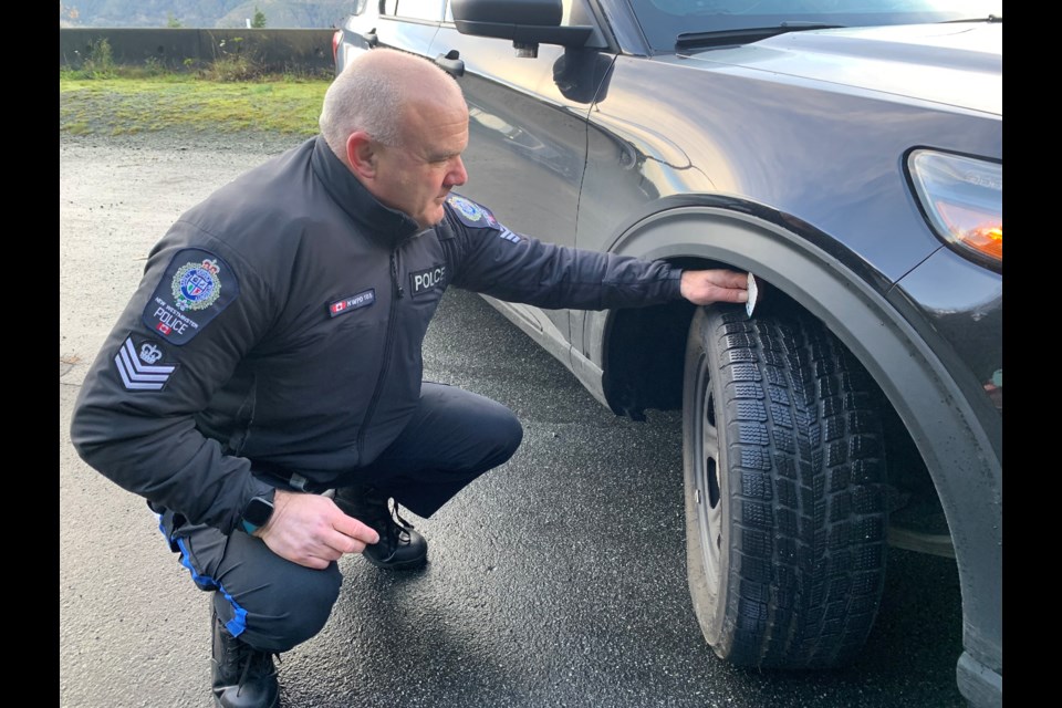 Staff Sgt. Stuart Jette with the Integrated Road Safety Unit of BC Highway Patrol demonstrates how deep tire tread should be on a patrol car.