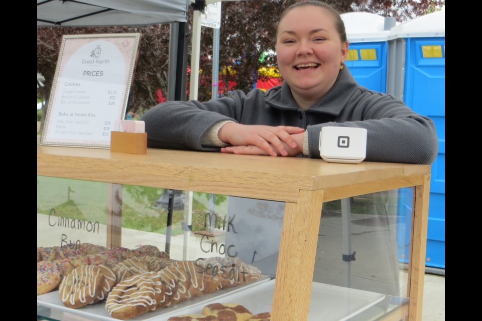 Mariah Beaudoin from Great North Cookie Company credits the "lovely" shoppers for keeping a smile on her face during the rainy St. Albert Farmers' Market opening on June. 8