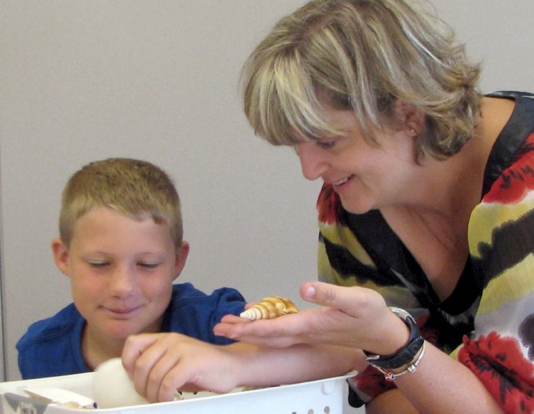 Grade 4 teacher Sandra Wood gives student Lucas Collins a hand as they learn about nature using seashells at the Morinville Public Elementary School.