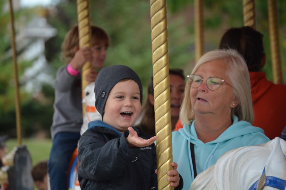 Bentley Rock and Grandma Wendy Triemstra on the merry-go-round.