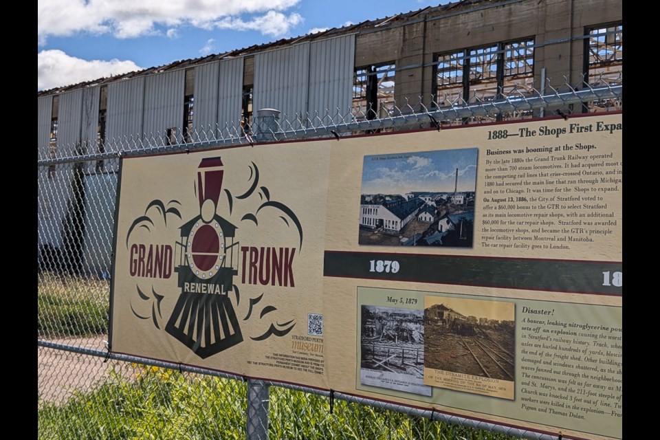 The Grand Trunk Renewal site mural attached to the fence blocking off the buildings from the public parking area.