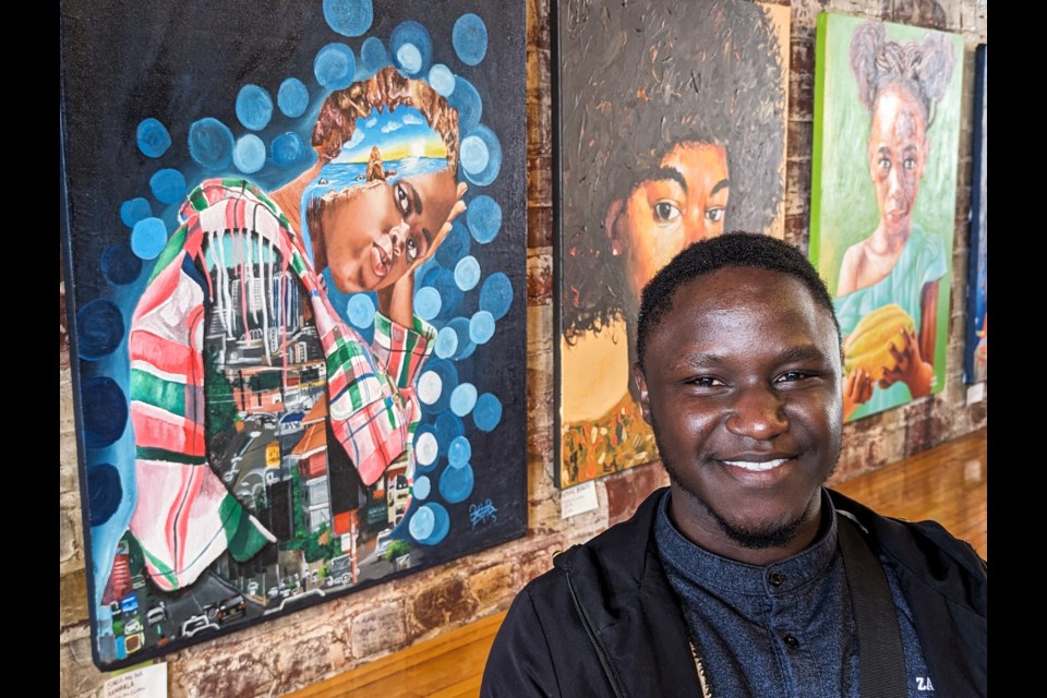 Artist Henry Bukenya shows off just one of his works hanging on the walls of revel in Stratford.