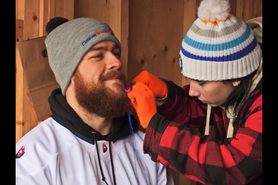 Joel McLeod of the Cleaver Brooks team gets a little hair tinsel in his beard before heading out for the Coldest Night of the Year walk around the Avon River on Saturday, Feb. 22. Olivia Young makes sure his decoration is firmly attached.        