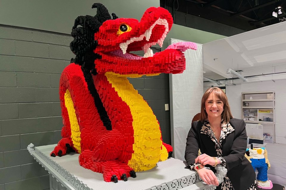 Science North CEO Ashley Larose stands beside a dragon sculpture built from Lego by artist Sean Kenney, whose work is the focus of a new exhibit at the Sudbury science centre.