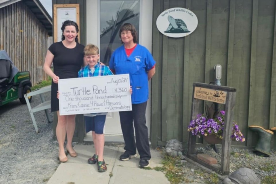 Izaak Parsons, 9, is owner of Cause4paws, a business that makes bandanas for pets. He donates $5 from each to wildlife causes, and is seen here with his mom Tiffany (left) and Gloria Morrisette of Turtle Pond Wildlife Centre after he donated $1,360 to the animal rehabilitation centre on Aug. 10.