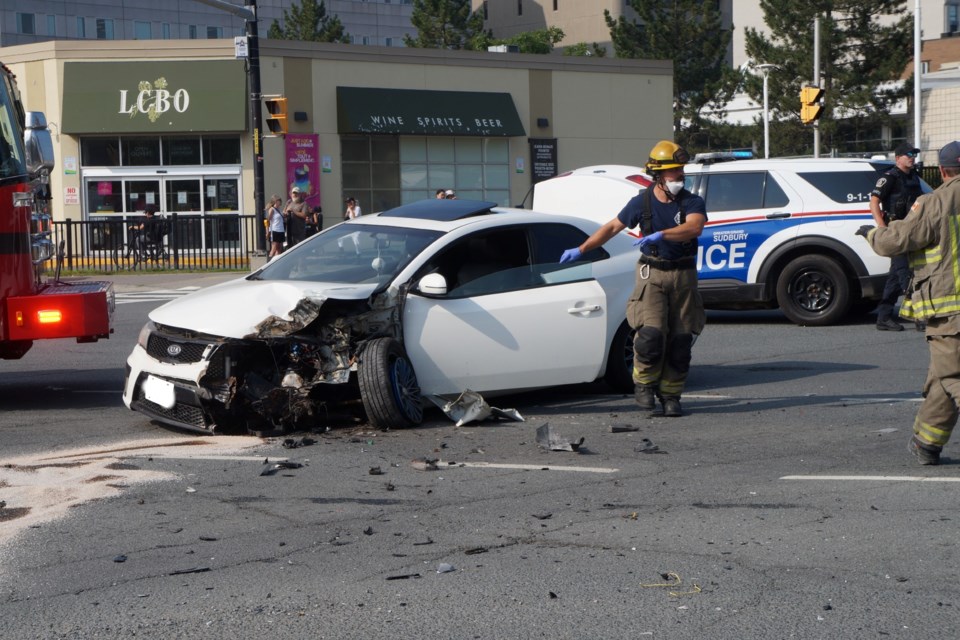 The car involved in the collision sitting at the cente of the intersection of Notre Dame and Elm with damage to the front. 