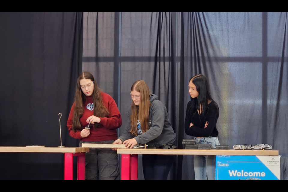 High school students test their bridge in the college's competition.