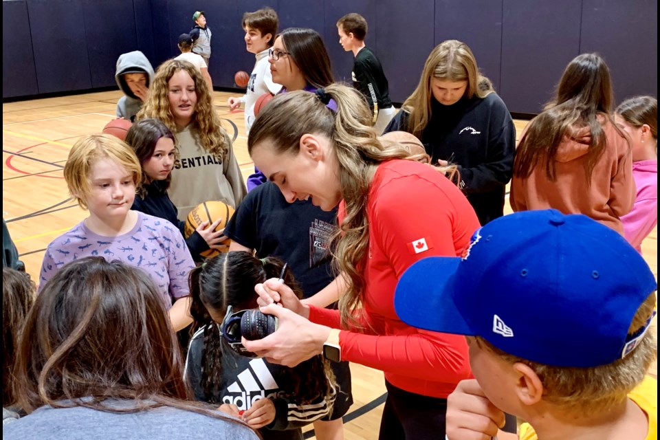 Canadian basketball Olympian Paige Crozon signs autographs for Kingsway Park Public School students on Tuesday. 