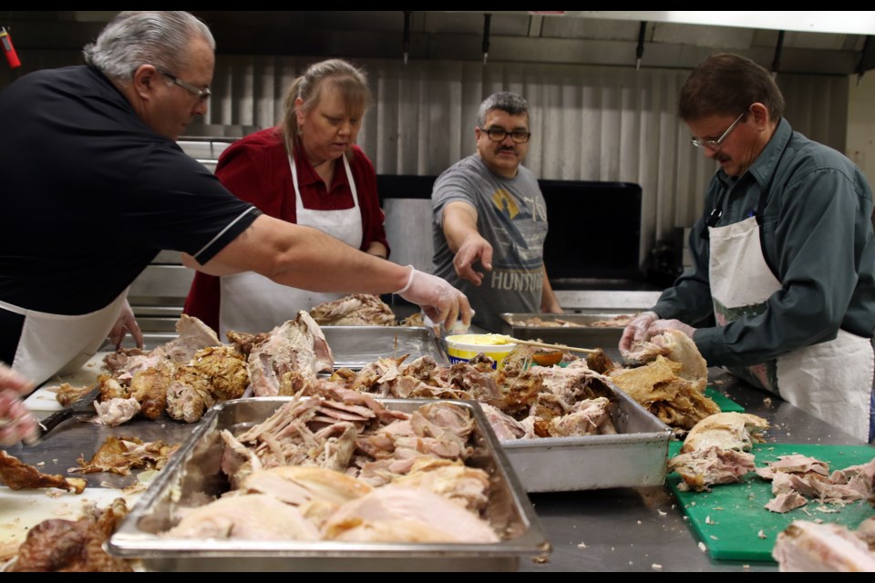 Dew Drop Inn volunteers began carving turkeys for nearly 400 people they expect to attend their Christmas dinner at 2 p.m. on Dec. 25.