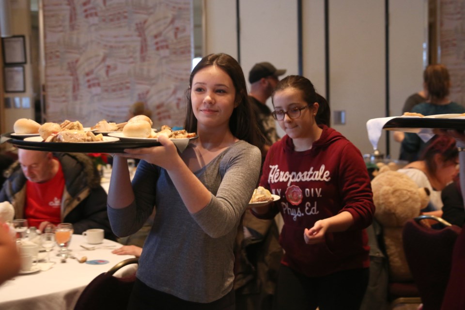 Volunteers serve up Christmas dinner with a smile during the 23rd Annual Salvation Army Christmas Dinner at the Valhalla Inn on Sunday. 