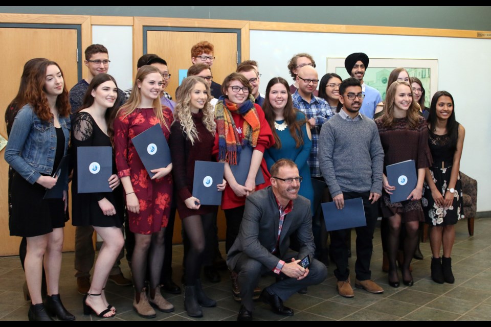 Graduates of the IB Program, along with program coordinator, Clarke Loney (centre), celebrate the completion of the rigorous academic program during a ceremony on Saturday. 