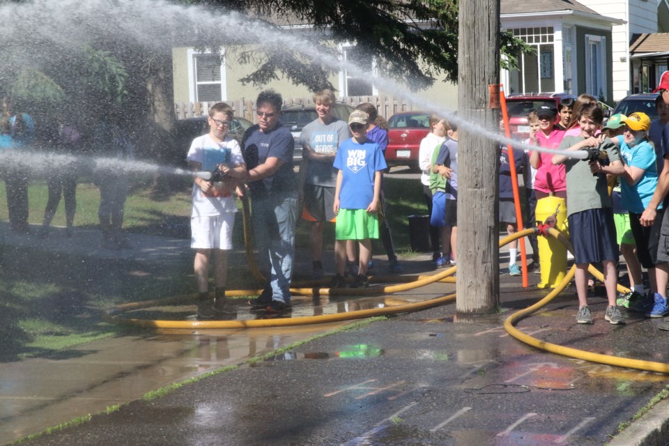 Students use the pressure hose at Pope John Paul II (Michael Charlebois, tbnewswatch.com).