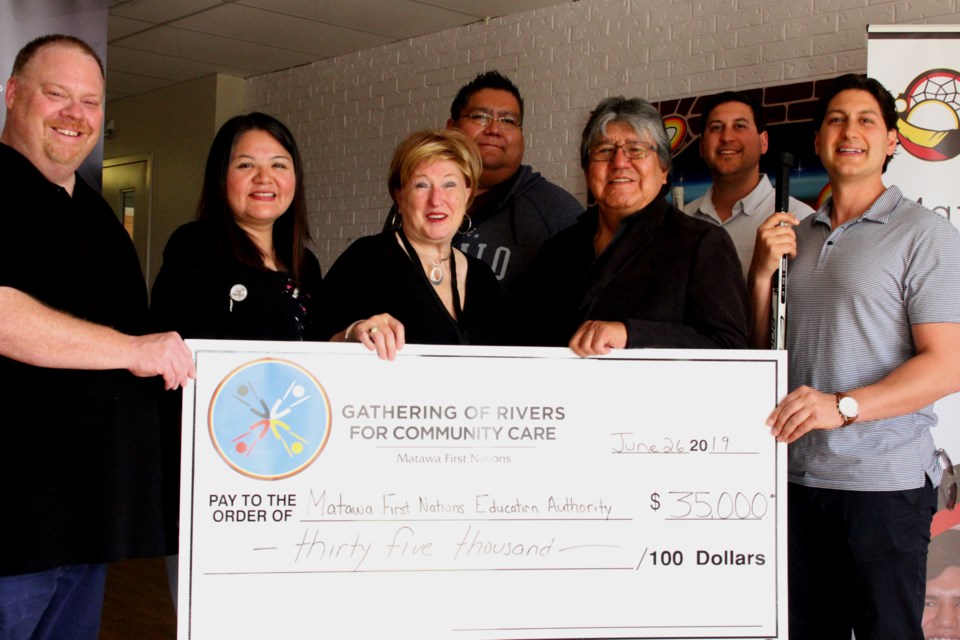 Brad Battiston (left), Sharon Nate, Bonnie Moore, Robinson Meshake, David Paul Achneepineskum, Steve Larizza, and Michael Larizza holding a $35,000 cheque - the first official donation to the Matawa First Nation Education Authority. (Michael Charlebois, tbnewswatch