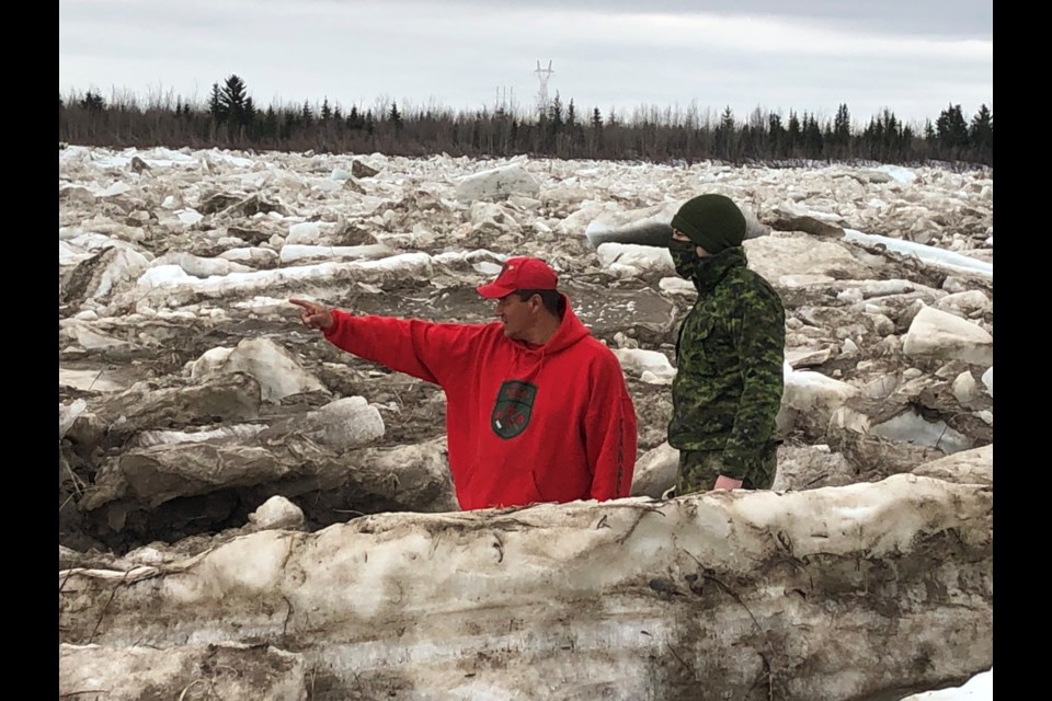 Master Corporal Joe Lazarus (l) shows Corporal Randy Jones, a visiting soldier, what to look for as the Albany River breaks up (photo by w/o Carl Wolfe)