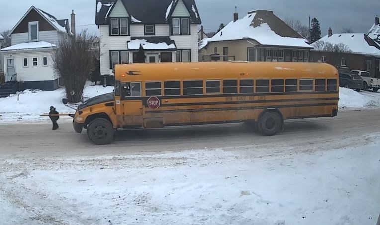 An image captured from a security camera shows a four-year-old boy almost being struck by a school bus after he was dropped off in front of his home on Dec. 12, 2022 (Facebook/Melanie Pelletier)