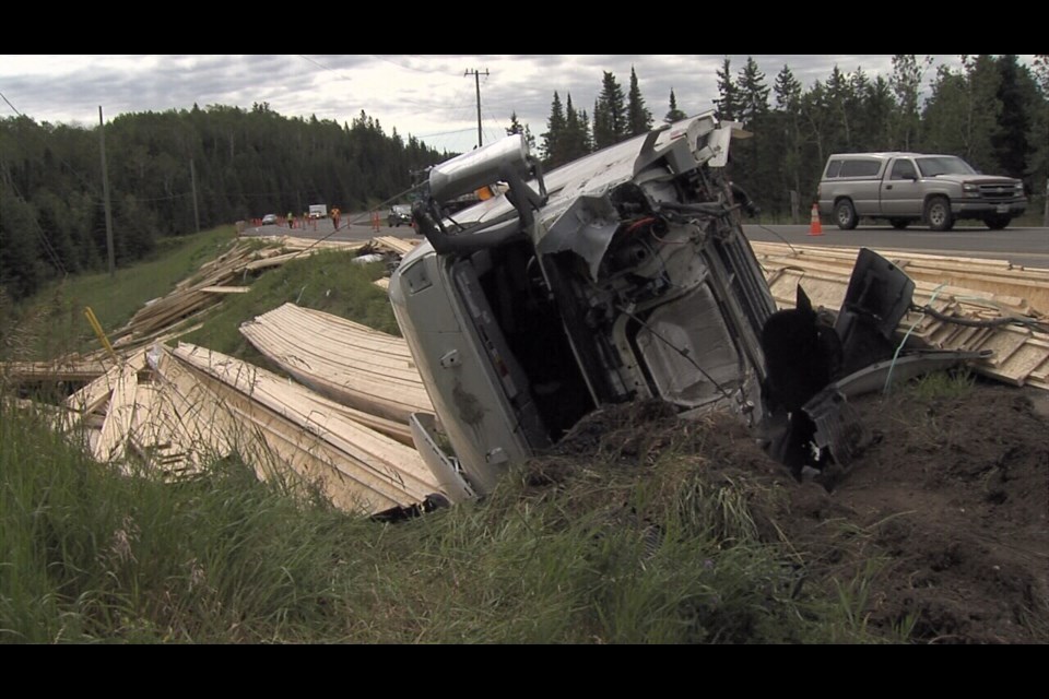 A tractor-trailer carrying floor joists overturned after hitting a deer on Highway 102 on July 26, 2022. (Leigh Nunan/TBTV photos)