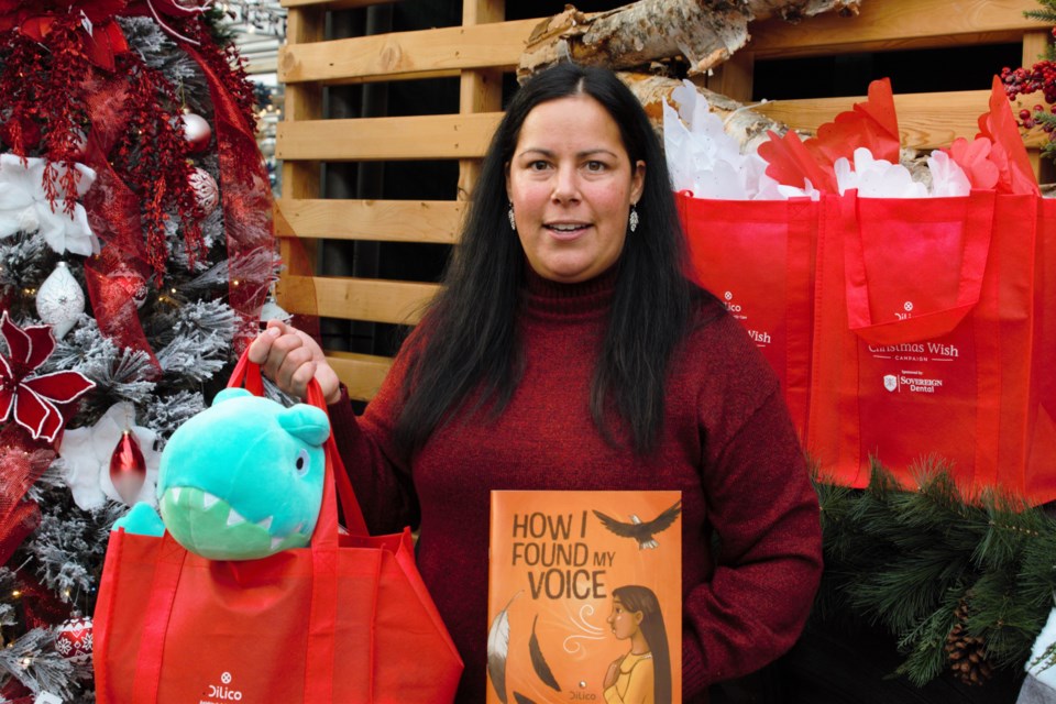 Tina Bobinski, director of mental health and addictions services with Dilico, shows off a gift bag and the How I Found My Voice children's book.  (Ian Kaufman, TBnewswatch)