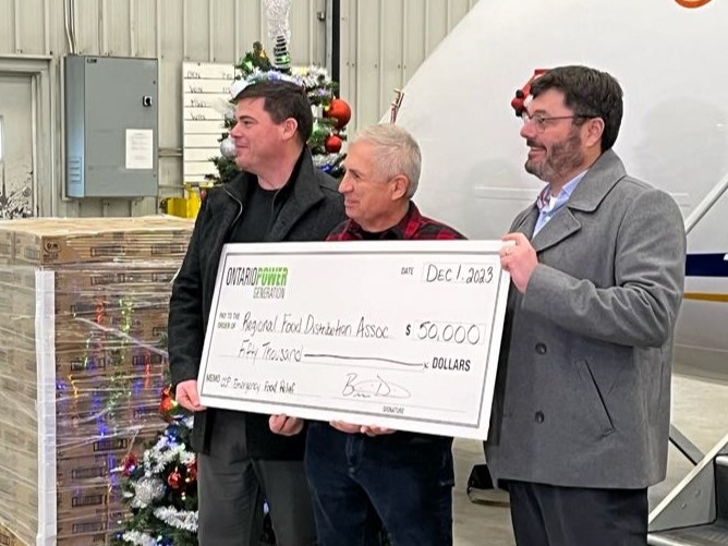 Ontario Power Generation (OPG) Director of Asset and Project Management Brian Dietrich (far right) presents a cheque to RFDA Executive Director Volker Kromm at the Wasaya Hangar on Friday, December 1, 2023
