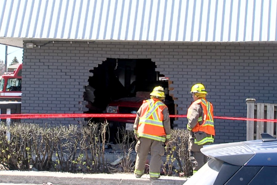 Emergency crews investigate the scene after a vehicle broke through the wall of Boston Pizza on Arthur Street