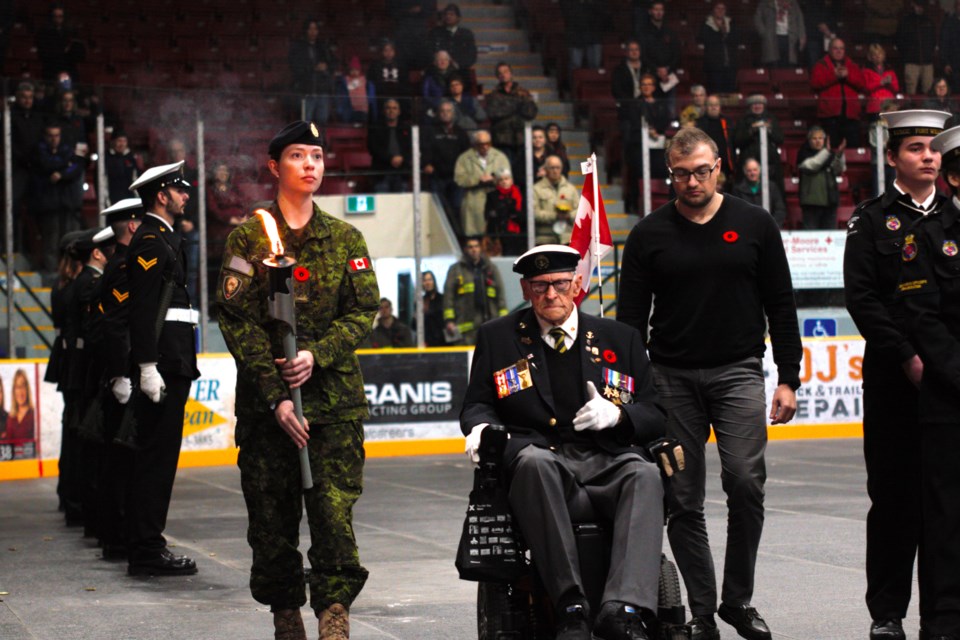 World War II veteran Cde. Elmer Auld (right) passed the torch to Pte. Kaitlyn Buhler of the 18 Service Battalion during the ceremony.