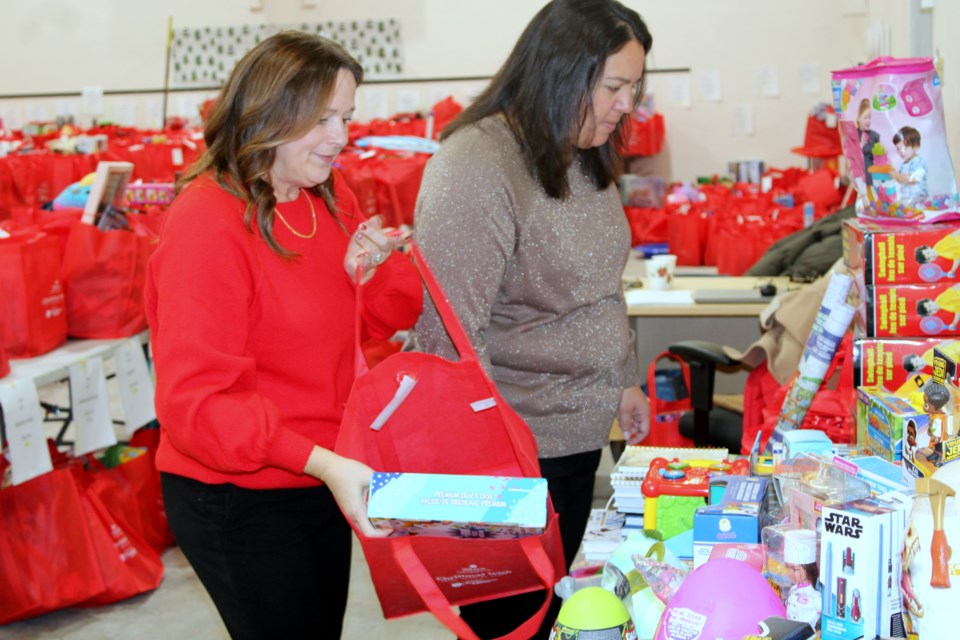 Pam Labelle, left, and Blythe Haynen fill up a wish bag at Dilico Anishinabek Family Care’s Christmas Wish campaign headquarters on Tuesday.