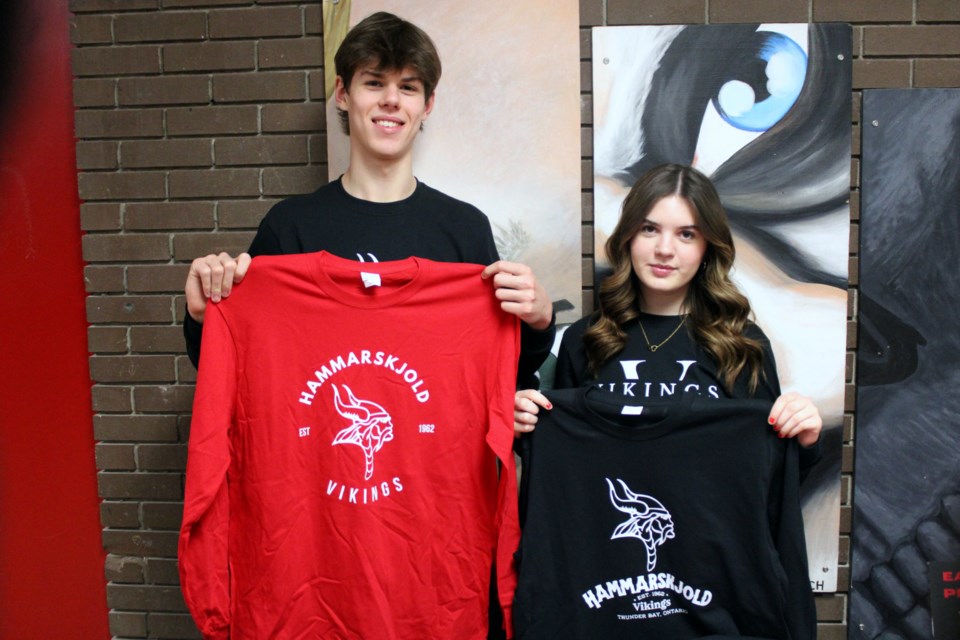 Grade 11 students Jack Baxter and Hannah Horslen showoff some of the apparel that they are selling as part of Viking Designs. 