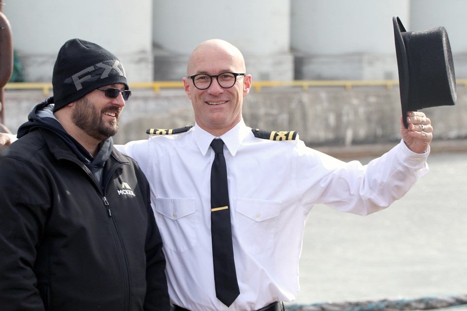 MV Harvest Spirit Capt. Adam Hagen (right) and first engineer, Gavin Pink, on Sunday, March 24, 2024 accept the ceremonial top hat, symbolic of the first lake-going vessel to arrive in Thunder Bay to open the shipping season. (Leith Dunick, tbnewswatch.com)