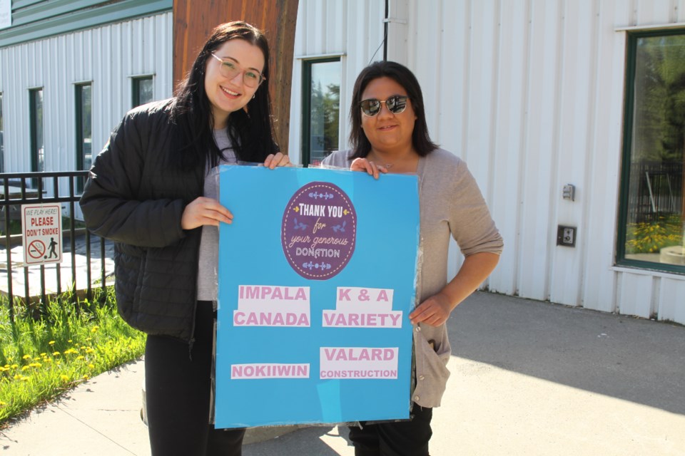 Alecia Boshcoff, consultation liaison officer, and Bobbi Bannon, environmental officer, hold a poster listing the companies that donated this year