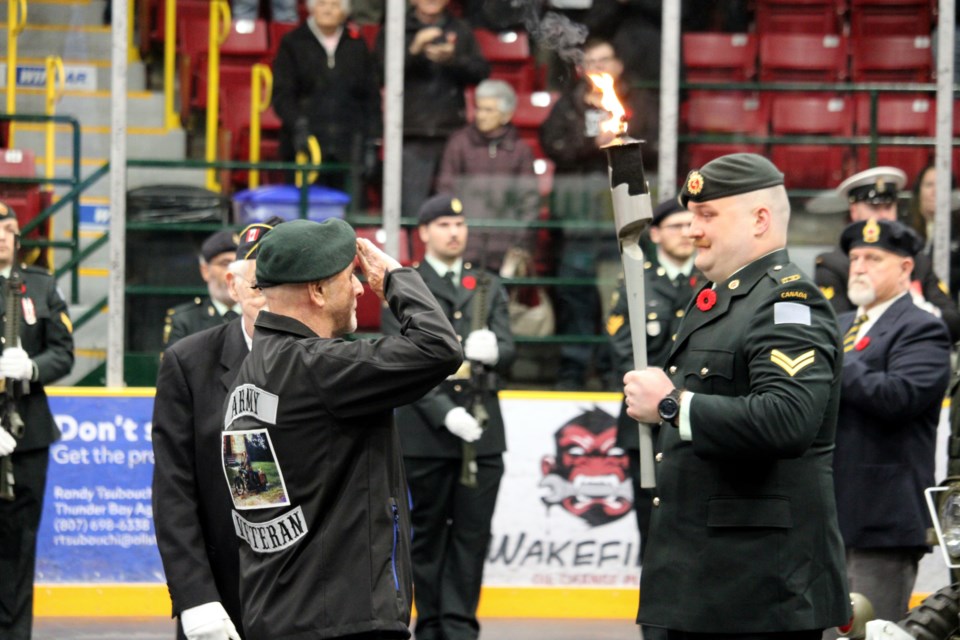 Cde. Preston Walker (left), a veteran of the Canadian Army, passes the torch to Corporal Riley Turner (right) of 18 Field Ambulance during the 2024 Remembrance Day Ceremony at Fort William Gardens.