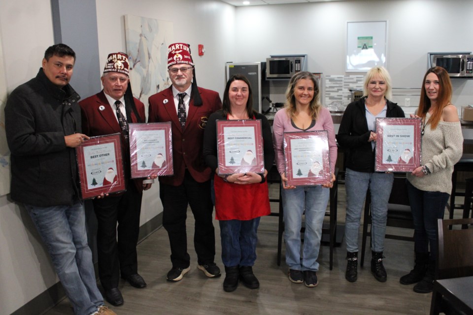 Clarence Fisher, left, of Nishnawbe Aski Nation, Ed Carr and Grant Poulin of the Lakehead Shrine Club, Jessica Berger of Balloon Stylings, Lori Ann Nelson of Spirit of Dance and Brenda Floyd and Jessica Lewis of Gary's Towing received Santa Claus Parade float awards on Nov. 28. 