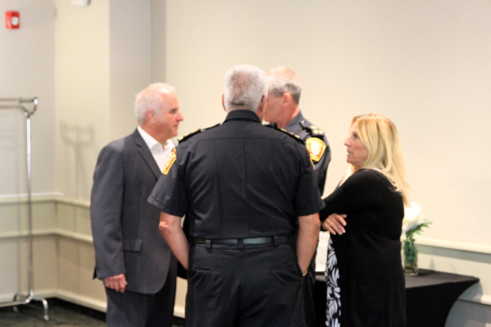 Police Chief Darcy Fleury, Wayne Bahlieda, Councillor Kasey Etreni, and Duty Chief Ryan Hughes discussing police board matters.