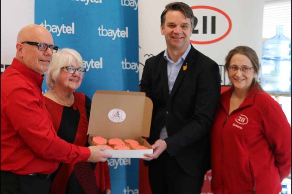 Albert Brulé, the United Way of Thunder Bay’s CEO; Marie Klassen, the Lakehead Social Planning Council executive director, and Paul Norris, Tbaytel’s president and CEO, left to right, hold a box of the limited edition persians with a volunteer. Brulé says 211 is an important service from which so many people benefit in the community and the region.