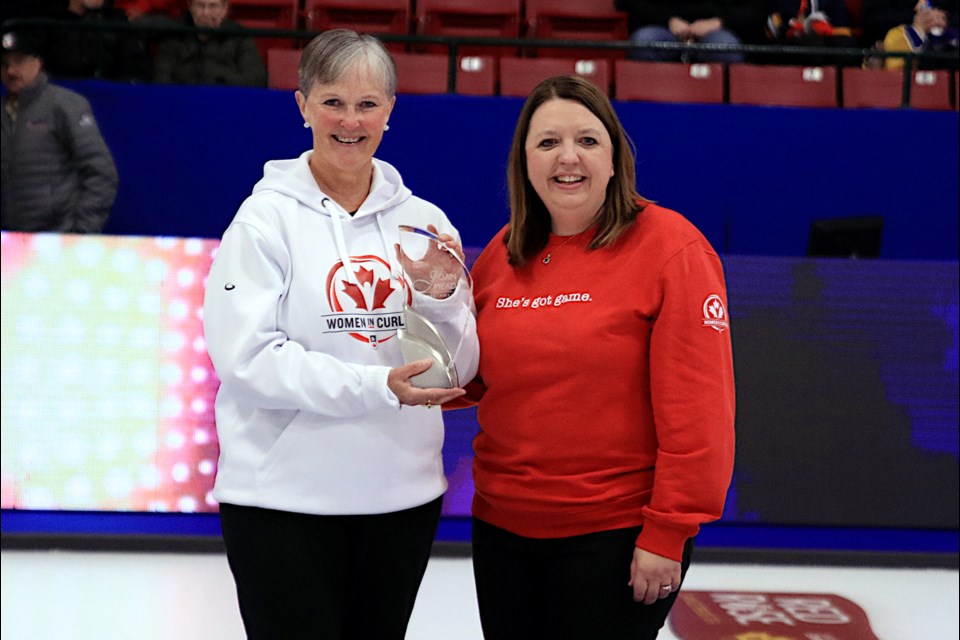 Curling Canada’s Officer of Sport Safety and Education, Jennifer Ferris, presents the Joan Mead Builder’s Award for the Scotties Tournament of Hearts to Andrea Ronnebeck.