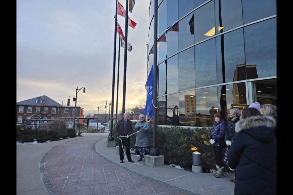 Sharon Pitawanakwat and Mayor Ken Boshcoff raise the flag on Jan. 2, 2025.