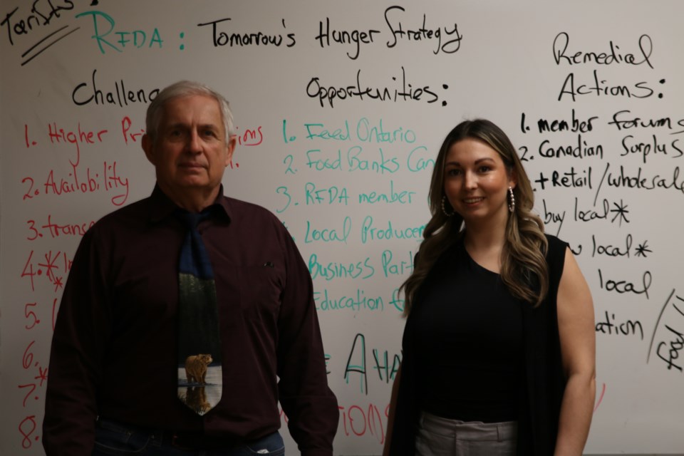 The Regional Food Distribution Association (RFDA) executive director, Volker Kromm, left, and April Mercier, the RFDA’s office manager, right, discuss what tariffs could mean for the organization.