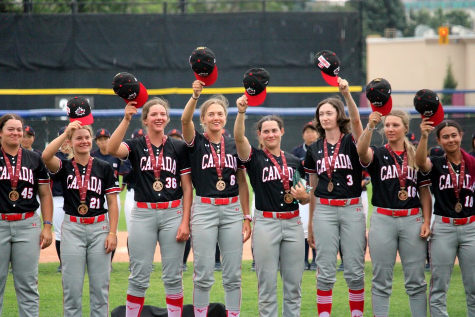 Members of the Canadian national women's baseball team salute the crowd at Port Arthur Stadium after receiving their bronze medals from the 2024 WBSC Women's Baseball World Cup.