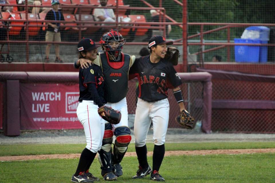 Mika Tai, left, Nanako Hanabusa and Akari Hoshikawa celebrate after Japan defeated Canada by a score of 7-6 at the WBSC Women's Baseball World Cup on July 29 at Port Arthur Stadium.